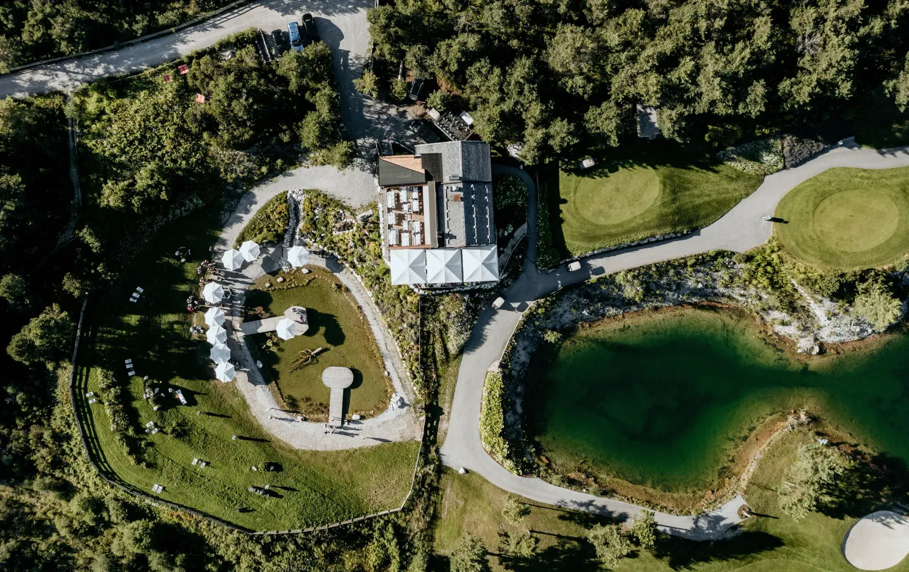 Luftaufnahme der Stöttlalm mit Terrasse, Stöttlalmsee und Golfplatz auf dem Mieminger Plateau
